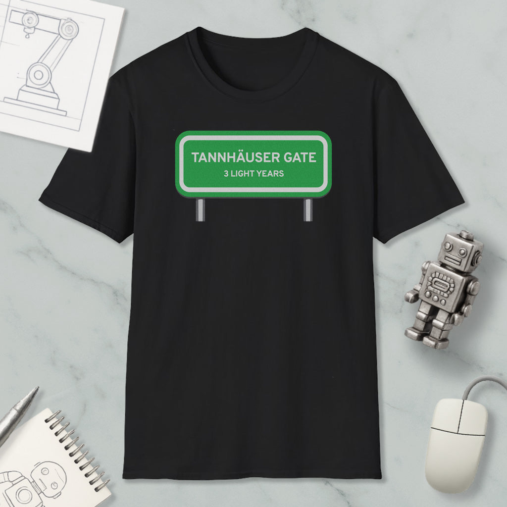 a black t-shirt with a green road sign that reads "Tannhäuser Gate" and "3 light years" printed on it. The t-shirt is placed on a marble surface, along with a small robot toy and a computer mouse.