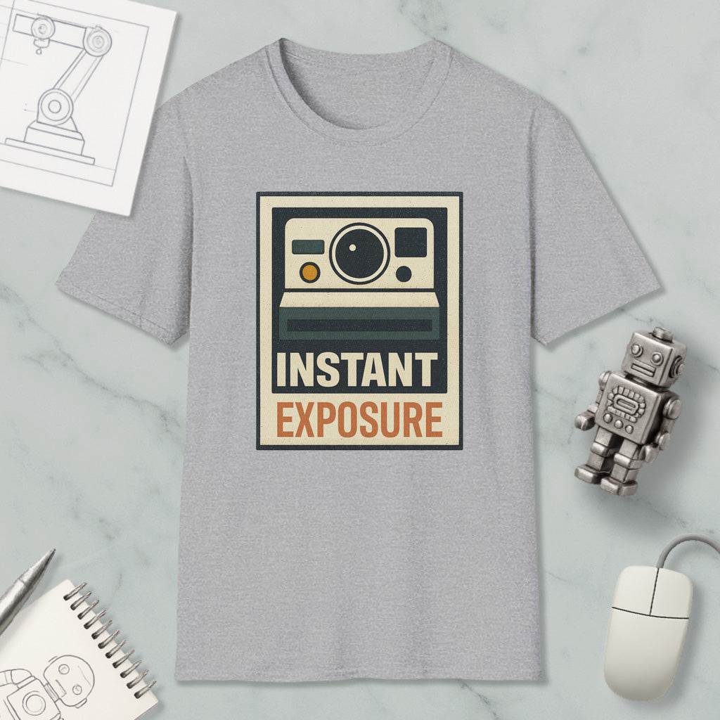 a gray t-shirt with a graphic design, a robot, a mouse, and some other items arranged on a marble surface.