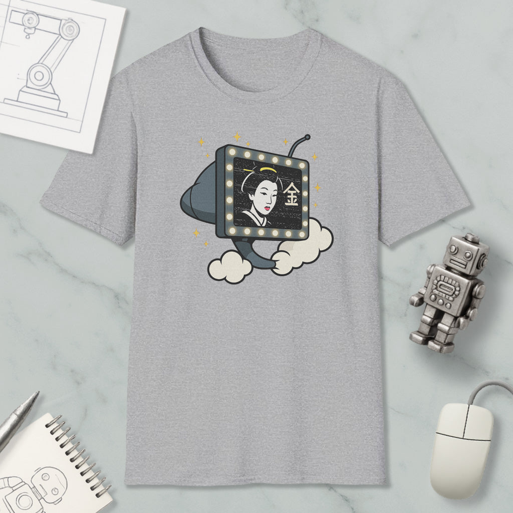 a gray t-shirt with a graphic design depicting a woman's face on a television screen, surrounded by clouds. The t-shirt is placed on a marble surface, along with a computer mouse, a notebook, and a small robot figurine.