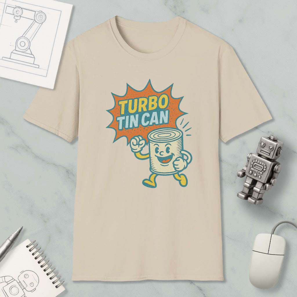 a beige t-shirt with a graphic design depicting a tin can character with a surprised expression, accompanied by the text "TURBO TIN CAN". The t-shirt is displayed on a marble surface, along with a small robot toy and a computer mouse.