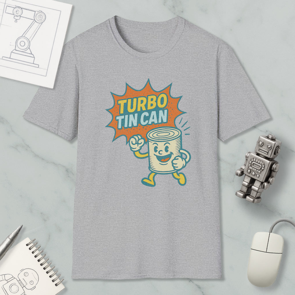 a gray t-shirt with a graphic design depicting a tin can character with a surprised expression, accompanied by the text "TURBO TIN CAN". The t-shirt is displayed on a marble surface, along with a computer mouse, a pen, and a notebook.