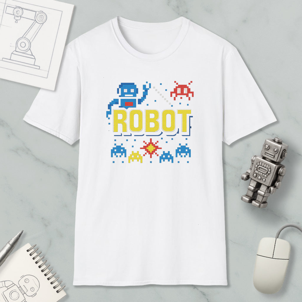 a white t-shirt with a robot graphic and pixel art elements, along with a computer mouse and a notebook.