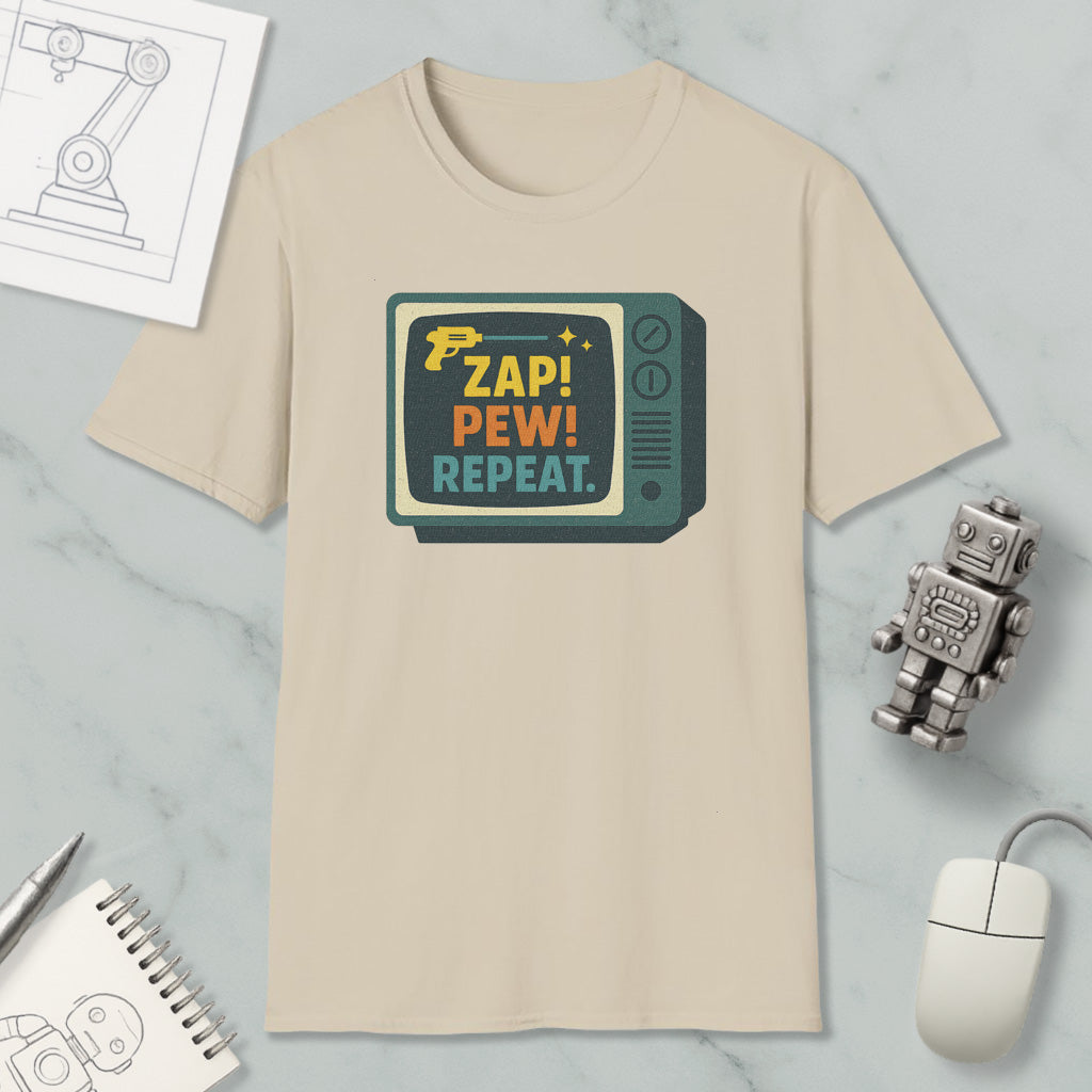 a beige t-shirt with a graphic design, a toy robot, a computer mouse, and some other items on a marble surface.