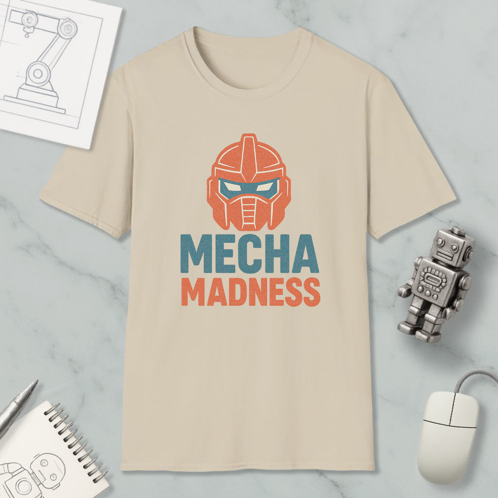 a beige t-shirt with a graphic design of a robot's head and the text "MECHA MADNESS" printed on it, along with a computer mouse and a notebook.