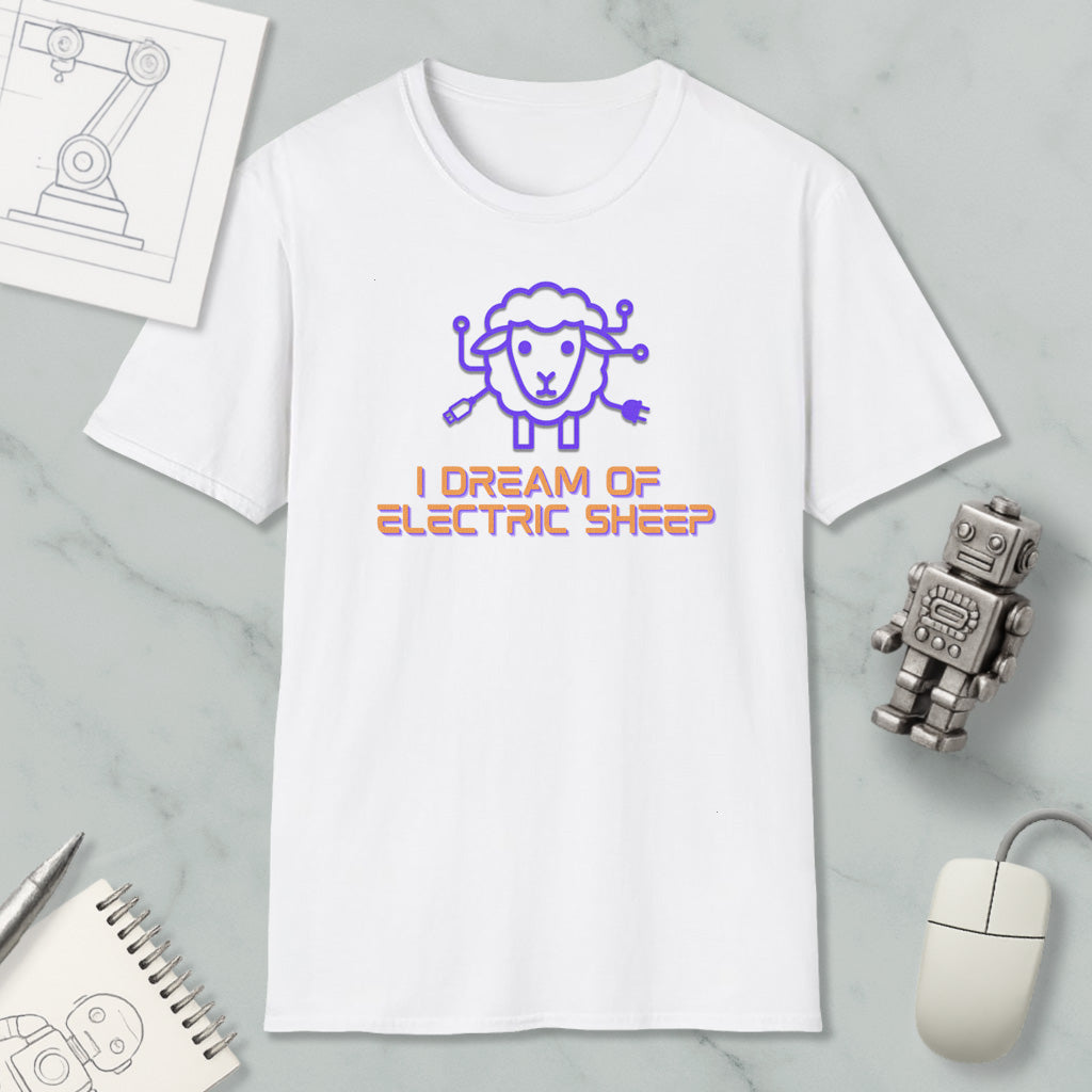 a white t-shirt with a graphic design of a sheep and the text "I DREAM OF ELECTRIC SHEEP" printed on it. The t-shirt is placed on a marble surface, along with a computer mouse, a pen, and a notebook.