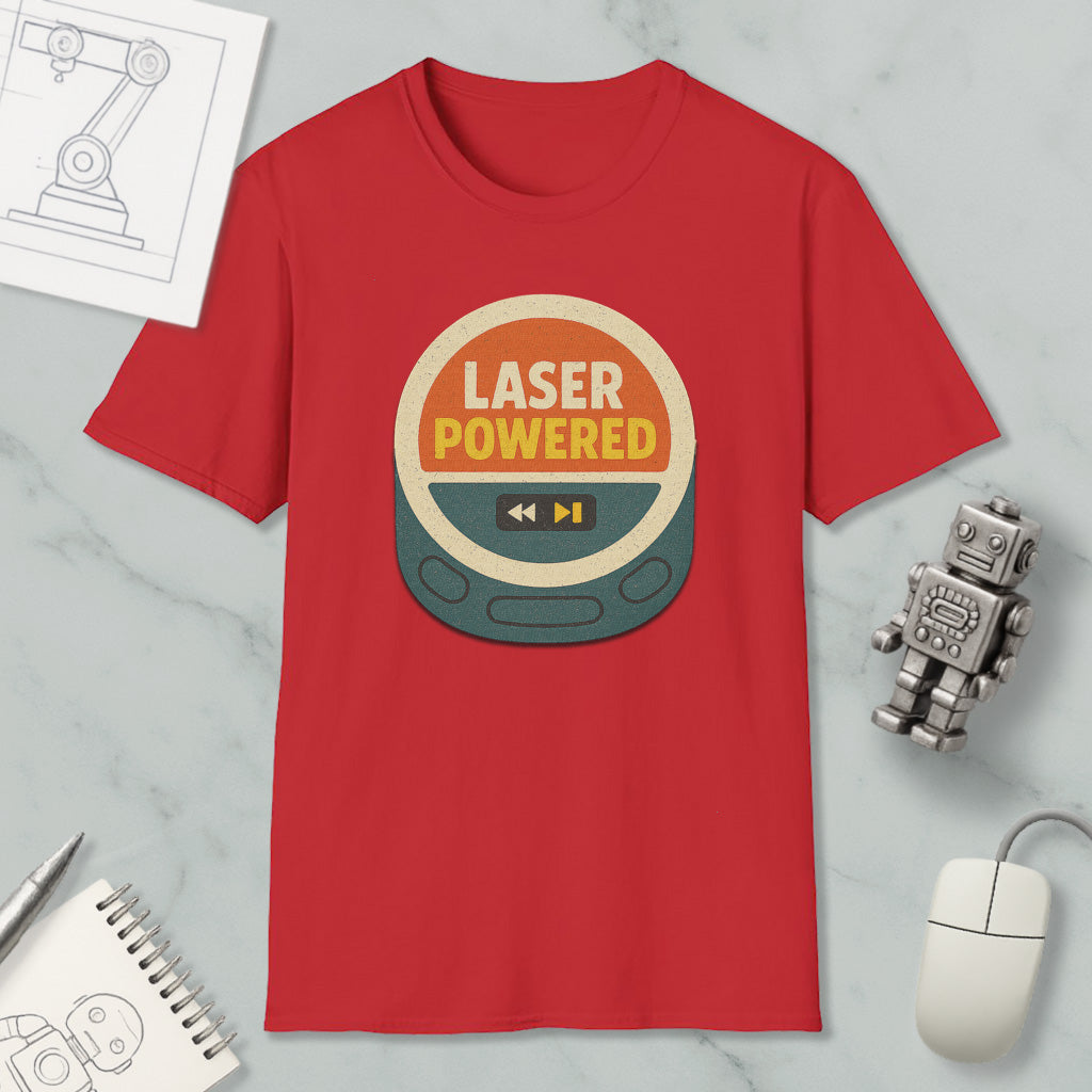 a red t-shirt with a graphic design, a computer mouse, a pen, a notebook, and a small robot on a marble surface.