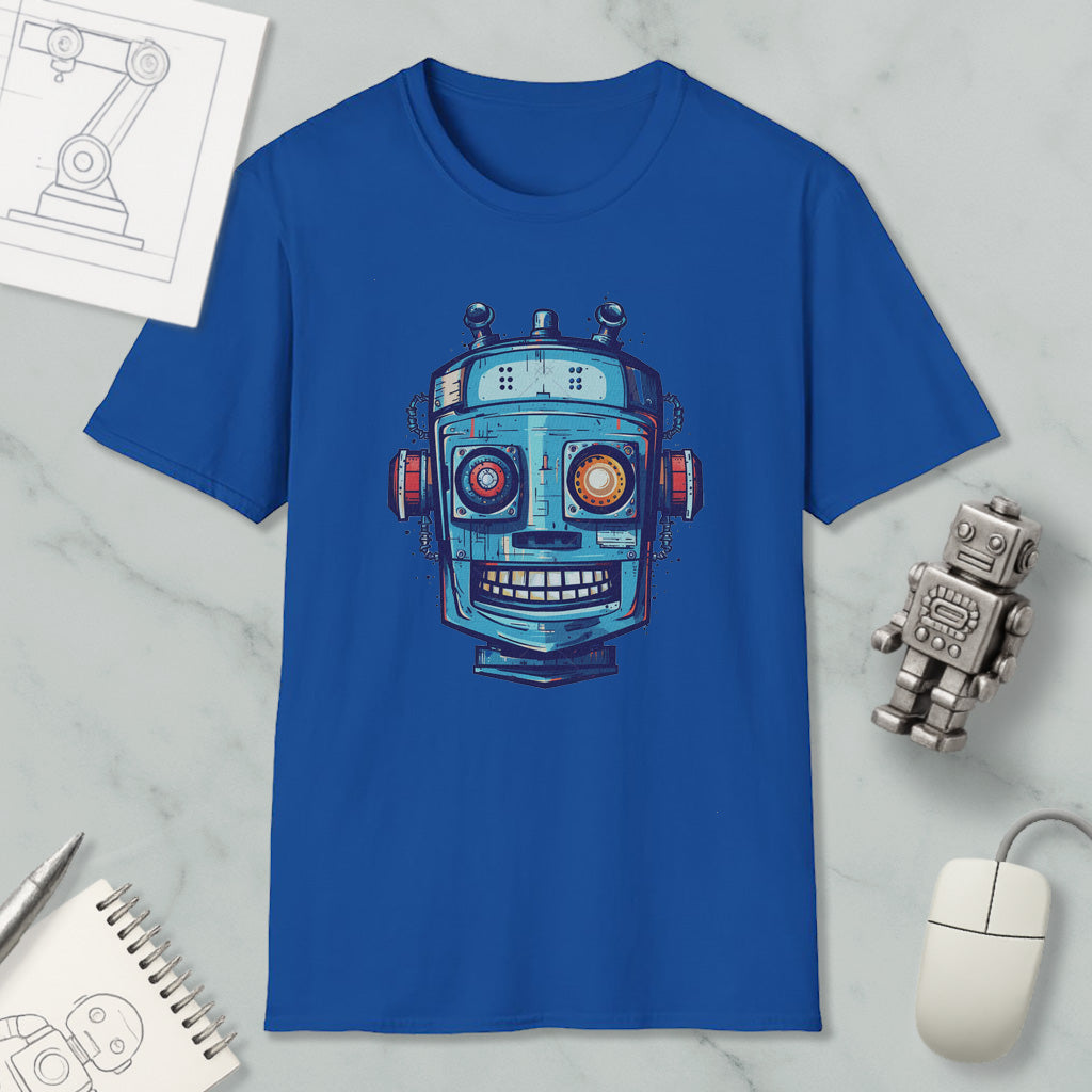 a blue t-shirt with a robot design, along with a computer mouse, a notebook, and a pen on a marble surface.