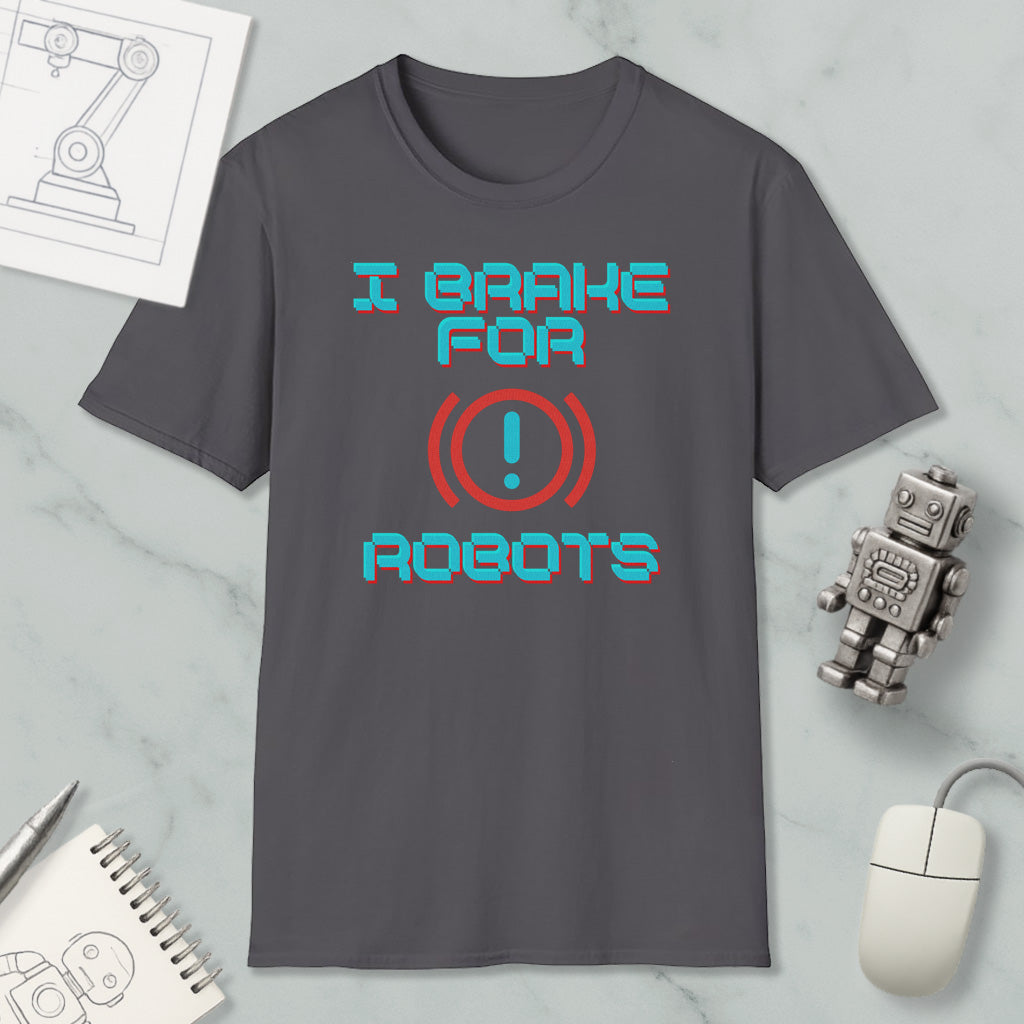 a gray t-shirt with a humorous text design, a small robot, a computer mouse, and some other items on a marble surface.