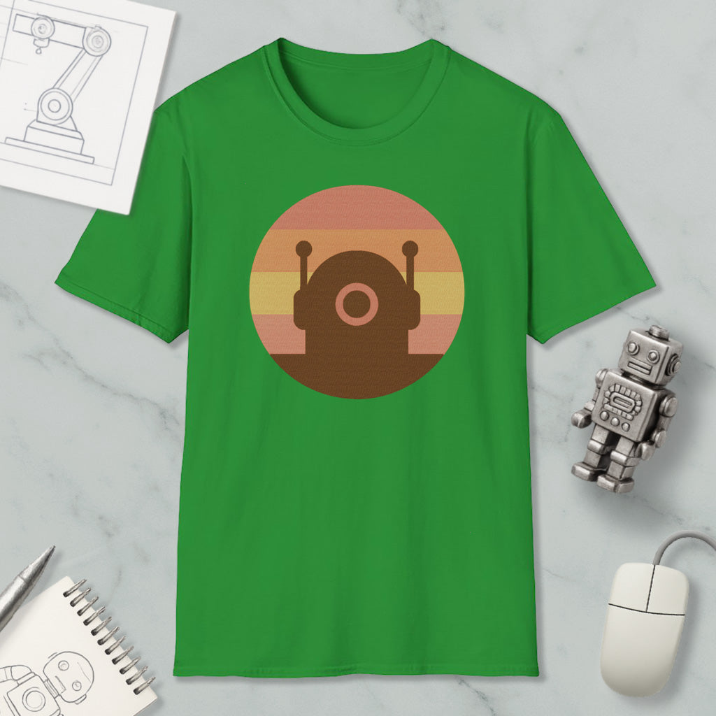 a green t-shirt with a circular graphic design, a small robot, a computer mouse, and a notebook on a marble surface.