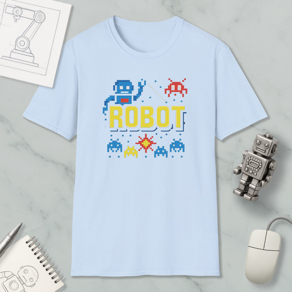 a light blue t-shirt with a robot graphic and pixel art elements, along with a computer mouse and a notebook.