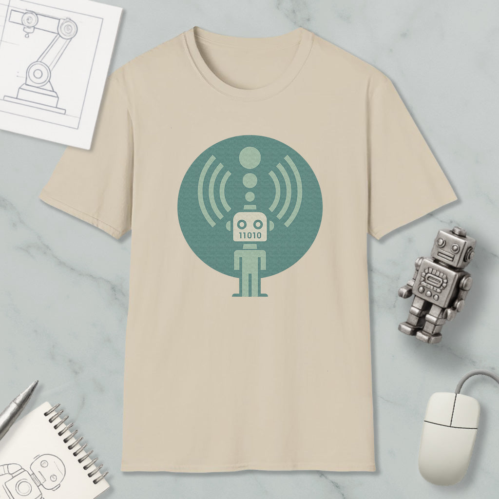a beige t-shirt with a graphic design of a robot, a mouse, and a notebook on a marble surface.