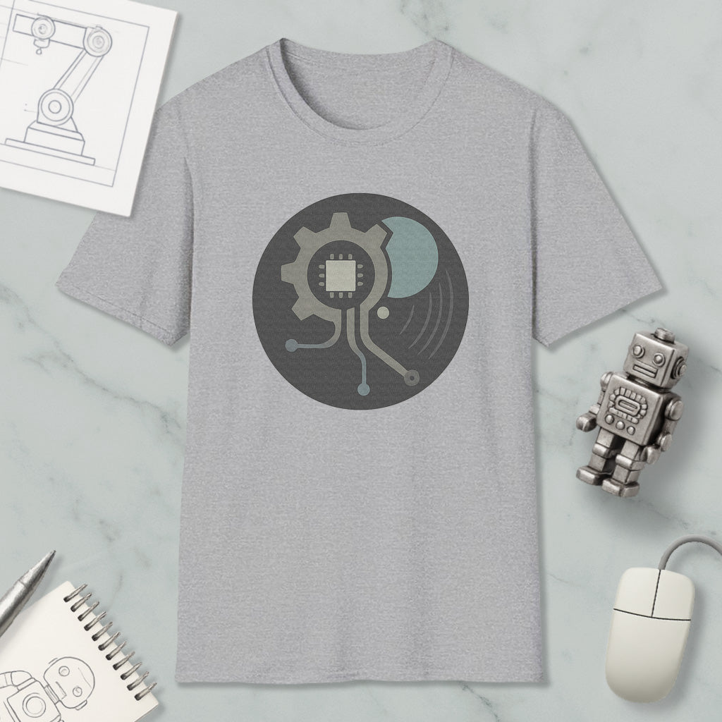 a gray t-shirt with a graphic design, a small robot, a computer mouse, and a notebook on a marble surface.