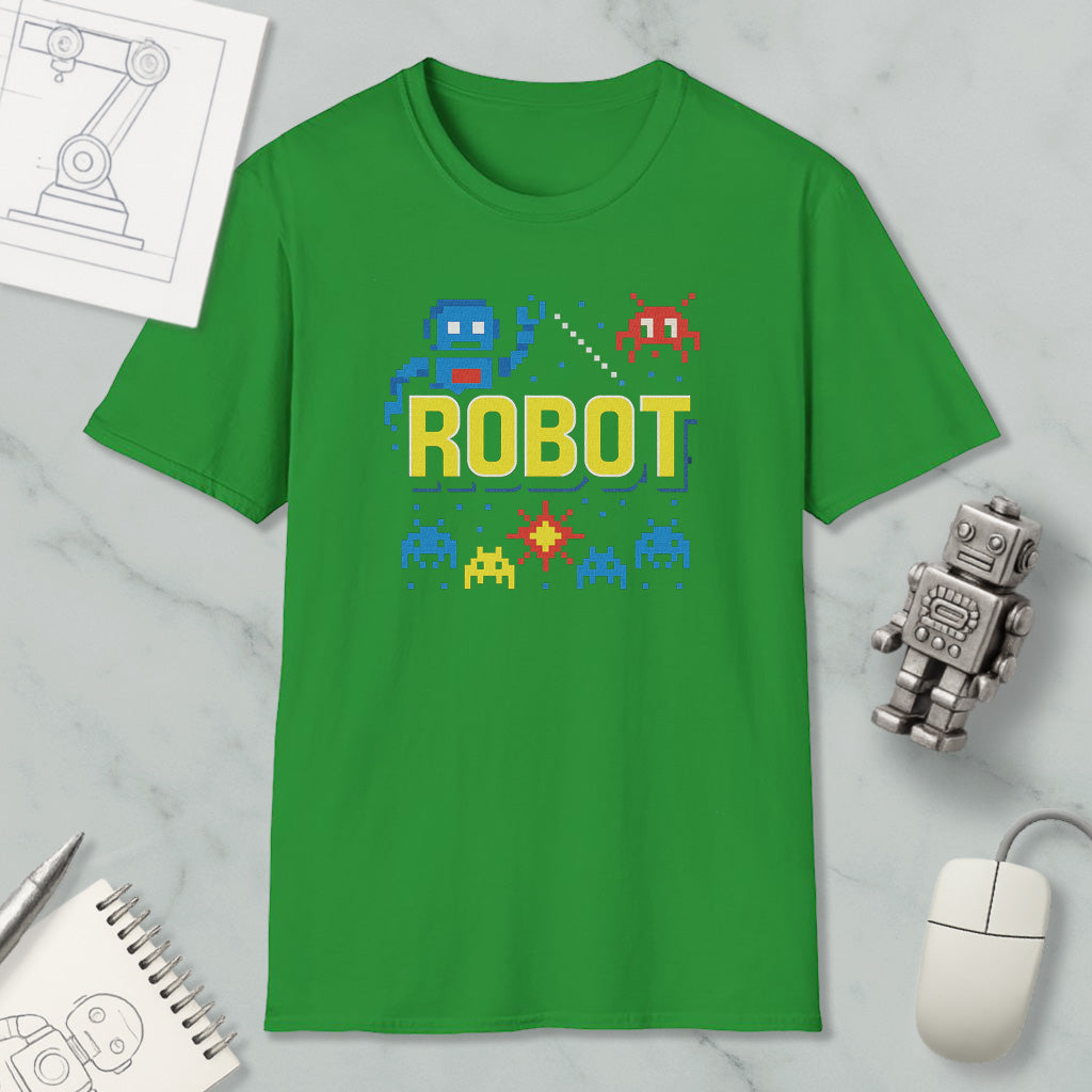 a green t-shirt with a robot graphic and pixel art, along with a computer mouse, a notebook, and a small robot figurine.