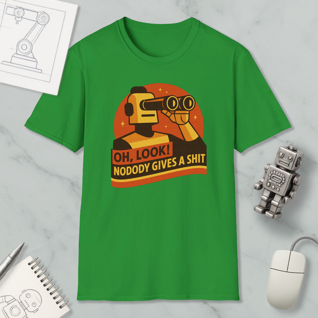 a green t-shirt with a graphic design depicting a robot character and the text "OH, LOOK! NODODY GIVES A SHIT" printed on it. The t-shirt is displayed on a marble surface, along with a computer mouse, a pen, and a notebook.