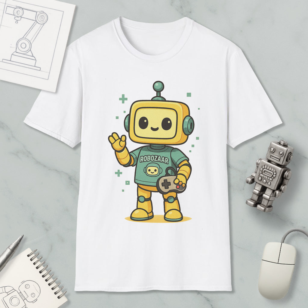a white t-shirt with a cartoon robot character wearing a green shirt and holding a game controller. The t-shirt is displayed on a marble surface, along with a computer mouse, a pen, and a notebook.