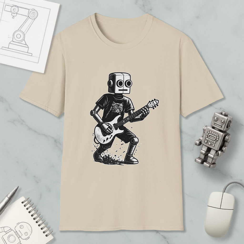 a beige t-shirt with a graphic of a robot playing a guitar, along with a computer mouse, a notebook, and a small robot figurine.