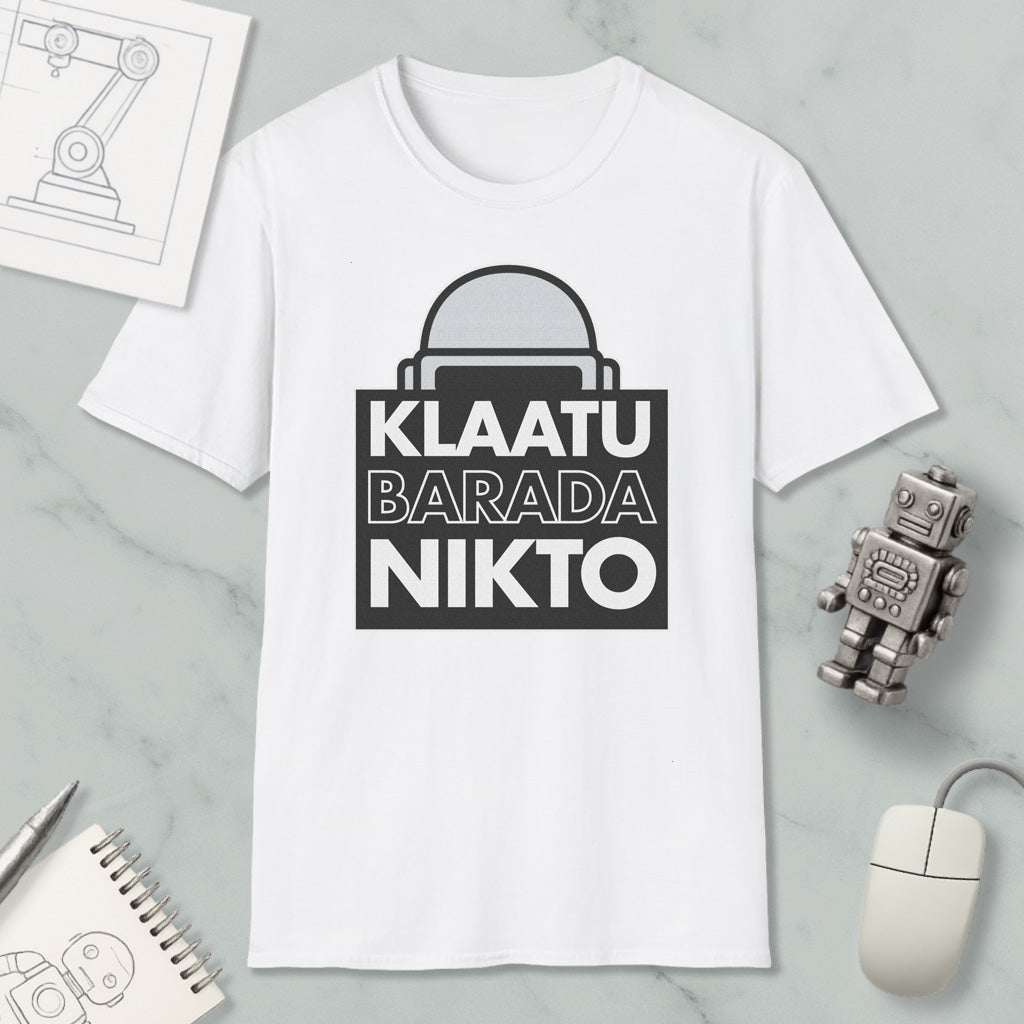 a white t-shirt with a graphic design, a computer mouse, a notebook, and a small robot figurine.