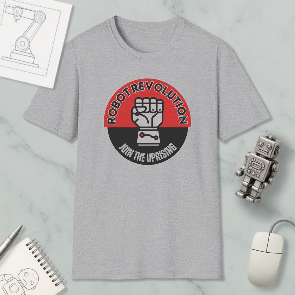a gray t-shirt with a graphic design, a robot toy, a computer mouse, and a notebook on a marble surface.