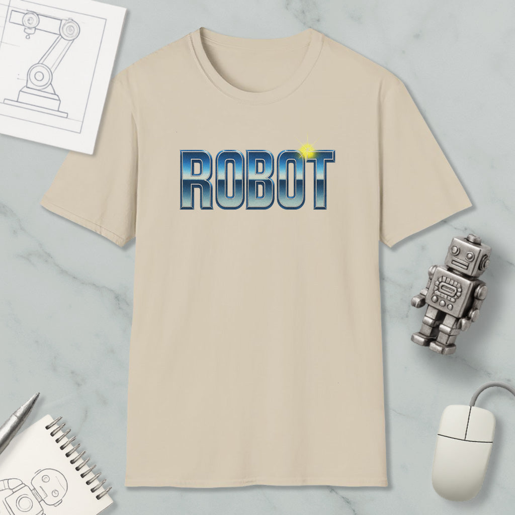 a beige t-shirt with the word "ROBOT" printed on it, along with a small robot toy and some other items such as a notebook and a mouse.