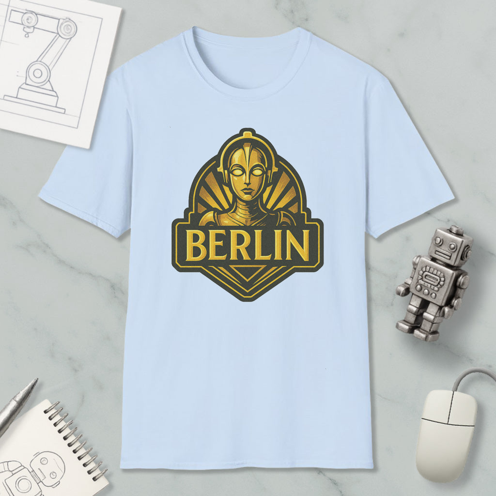 a light blue t-shirt with a graphic design of a robot or character, along with a computer mouse, a notebook, and a pen on a marble surface.