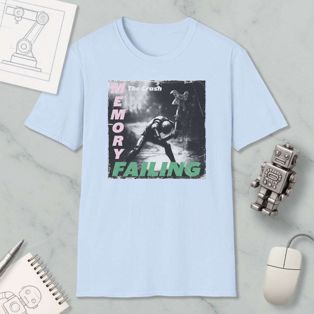 a light blue t-shirt with a graphic design depicting a person in a fighting stance, accompanied by the text "The Crash" and "Memory Failure". The t-shirt is displayed on a marble surface, along with various objects such as a computer mouse, a robot, and a notebook.