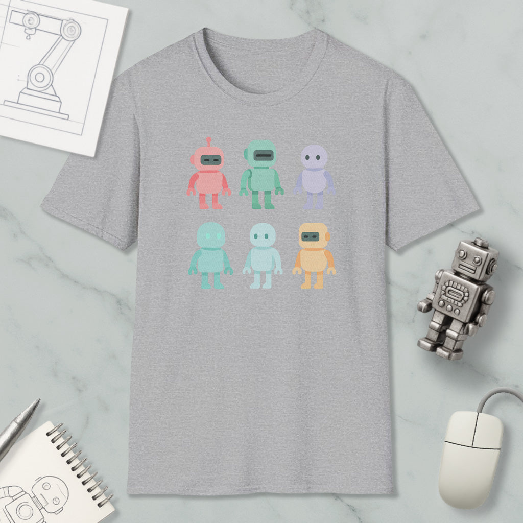 a gray t-shirt with a graphic design of six colorful robot characters, along with various office supplies such as a computer mouse, a notebook, and a pen.