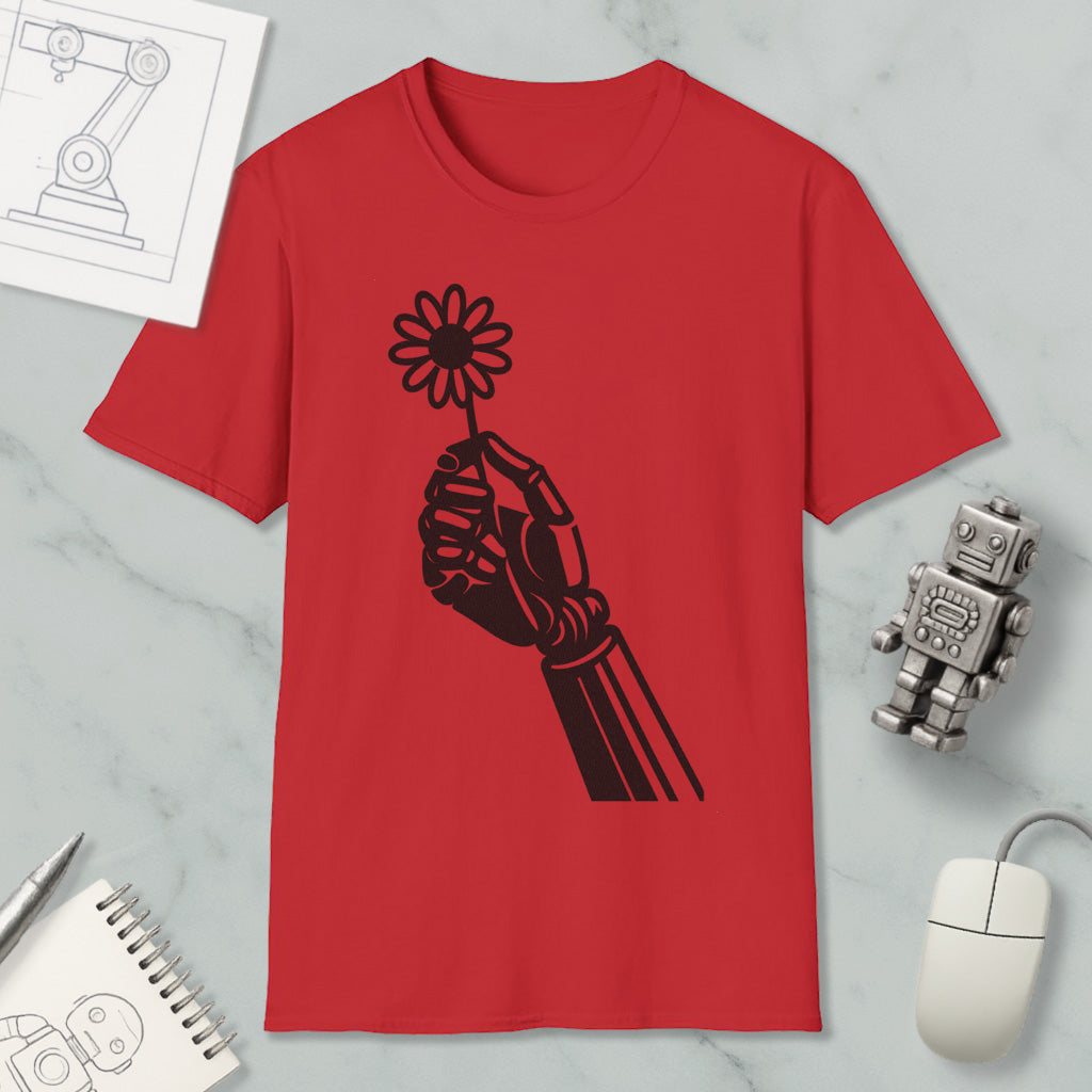 a red t-shirt with a black graphic design of a hand holding a flower, along with a computer mouse, a notebook, and a robot figurine.
