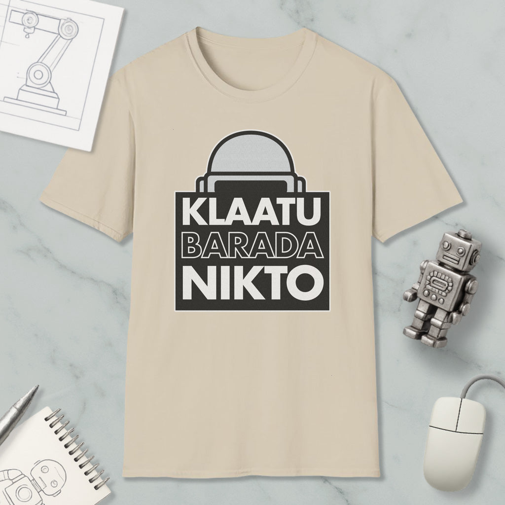 a beige t-shirt with a graphic design, a small robot, a computer mouse, and some papers on a marble surface.