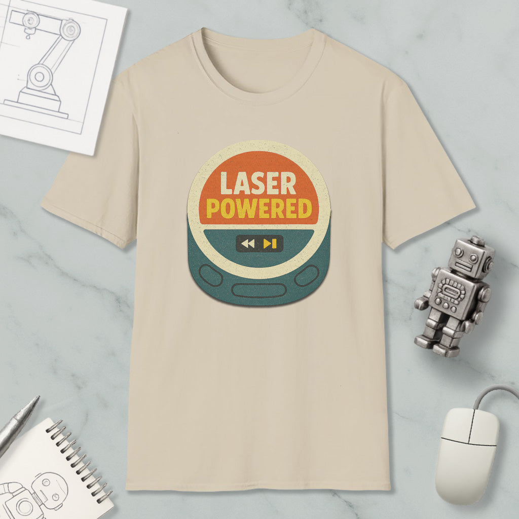 a beige t-shirt with a graphic design that says "LASER POWERED" in bold letters, surrounded by various objects such as a computer mouse, a robot, and a notebook.
