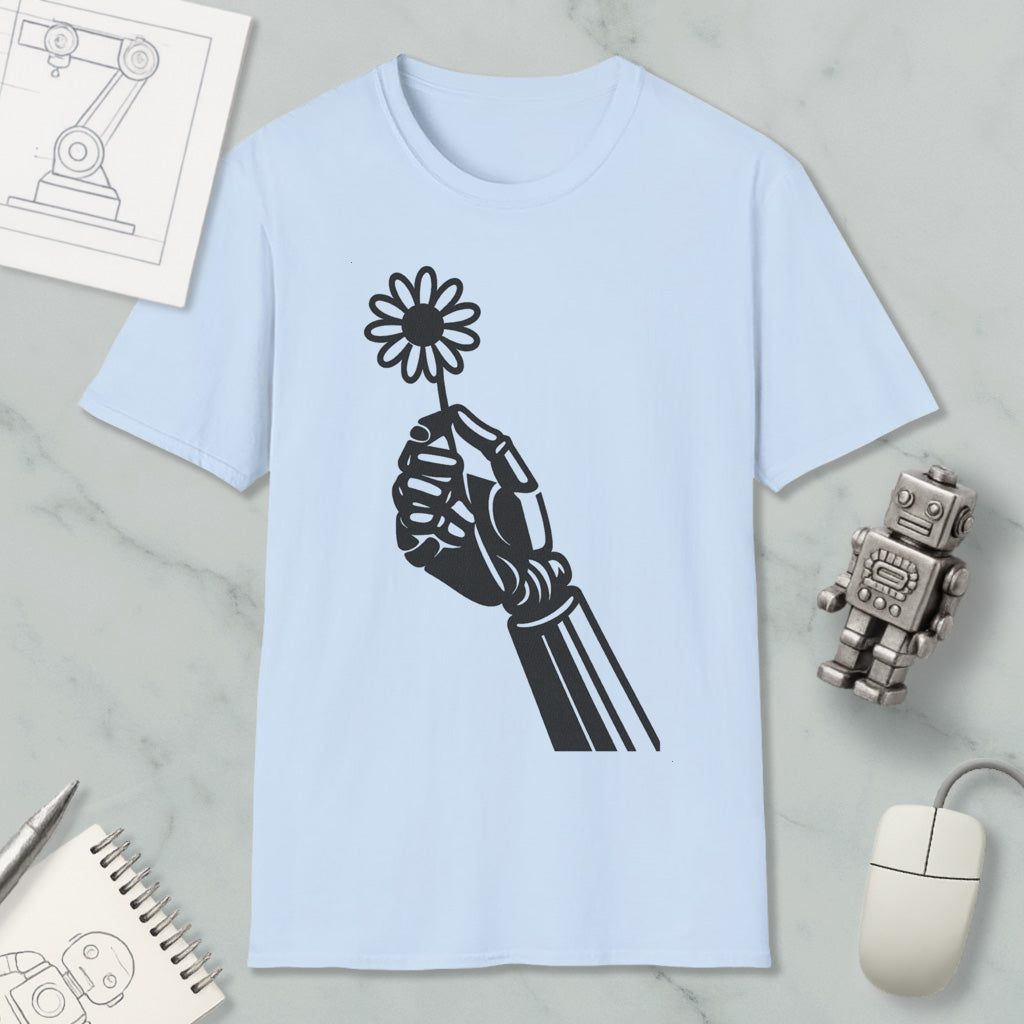 a light blue t-shirt with a black graphic design of a hand holding a flower, along with various objects such as a computer mouse, a robot, and a notebook.
