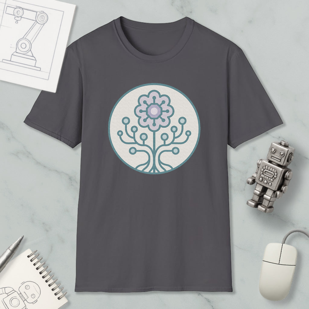 a gray t-shirt with a circular design on it, surrounded by various objects such as a computer mouse, a robot, and a notebook.