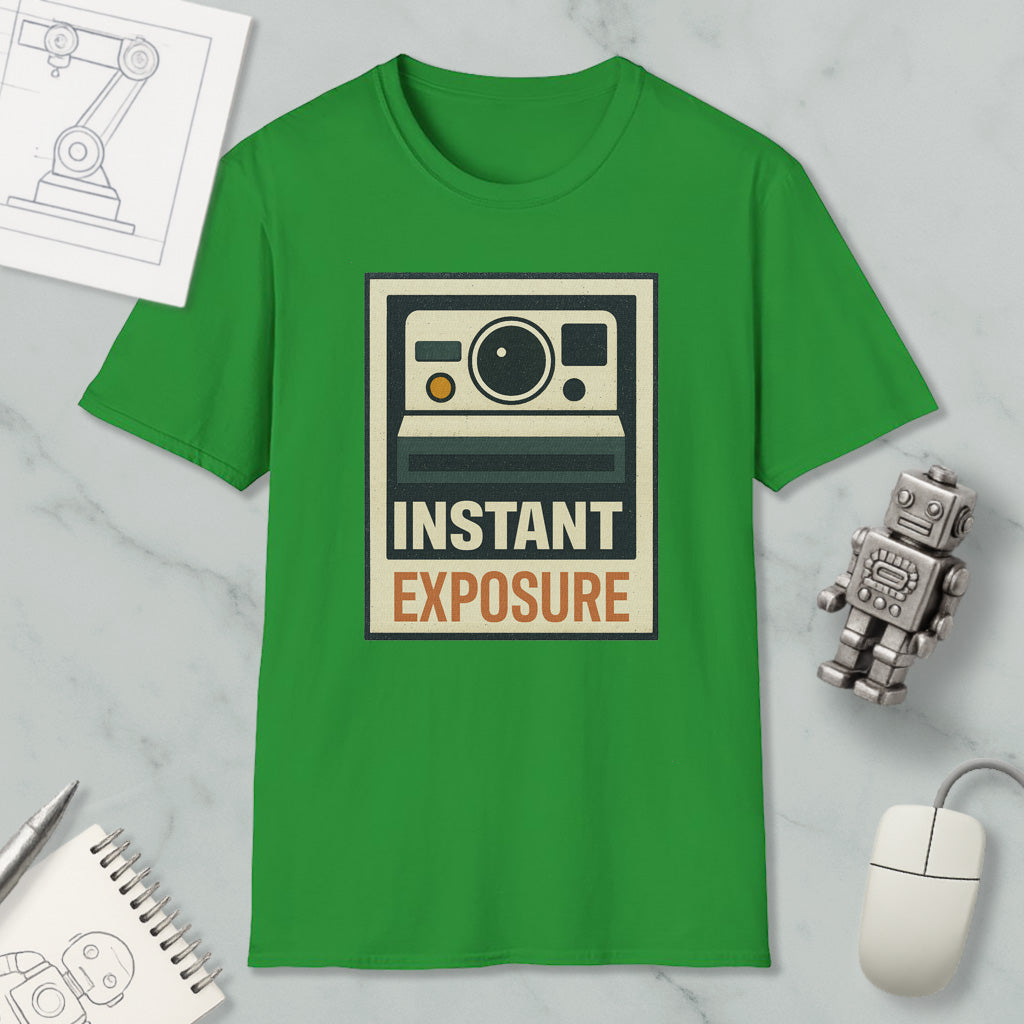 a green t-shirt with a graphic design, a computer mouse, a notebook, and a small robot on a marble surface.