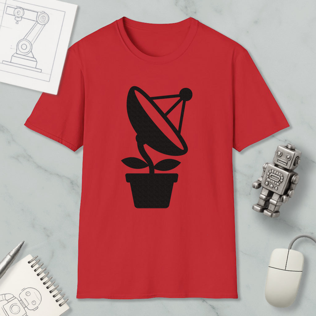 a red t-shirt with a black satellite dish graphic, along with a small robot and a computer mouse, all placed on a marble surface.
