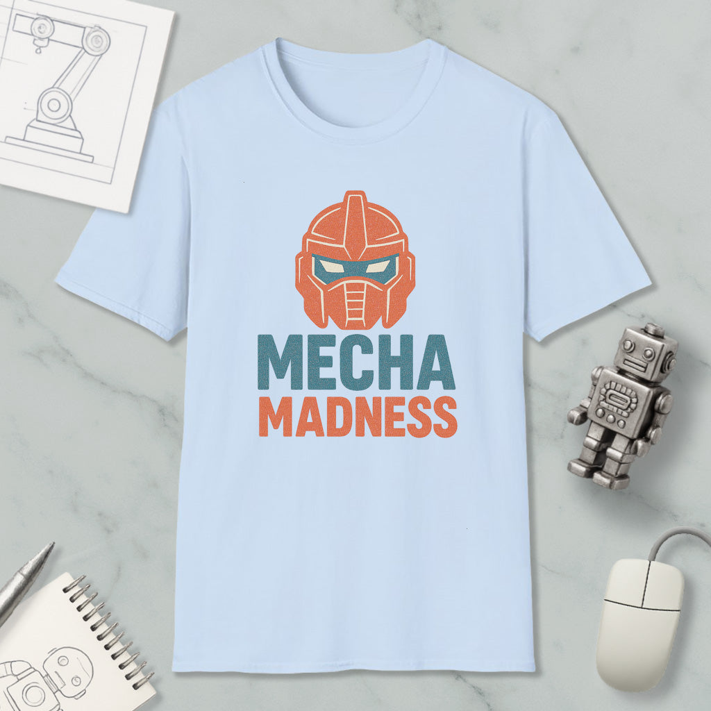 a light blue t-shirt with a graphic design of a robot's head and the text "MECHA MADNESS" printed on it, along with a computer mouse and a notebook.
