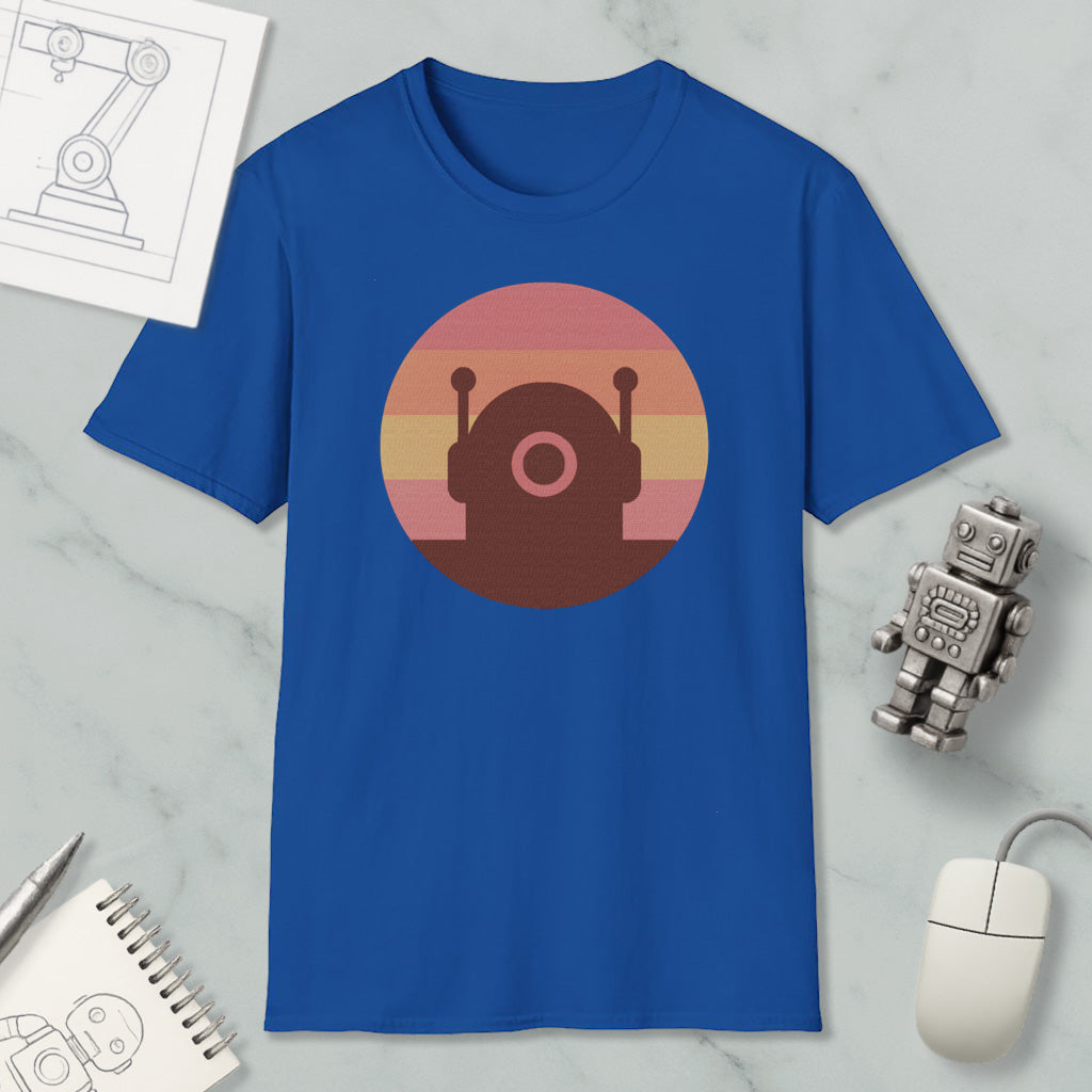 a blue t-shirt with a circular graphic design, a small robot figurine, a computer mouse, and a notebook on a marble surface.