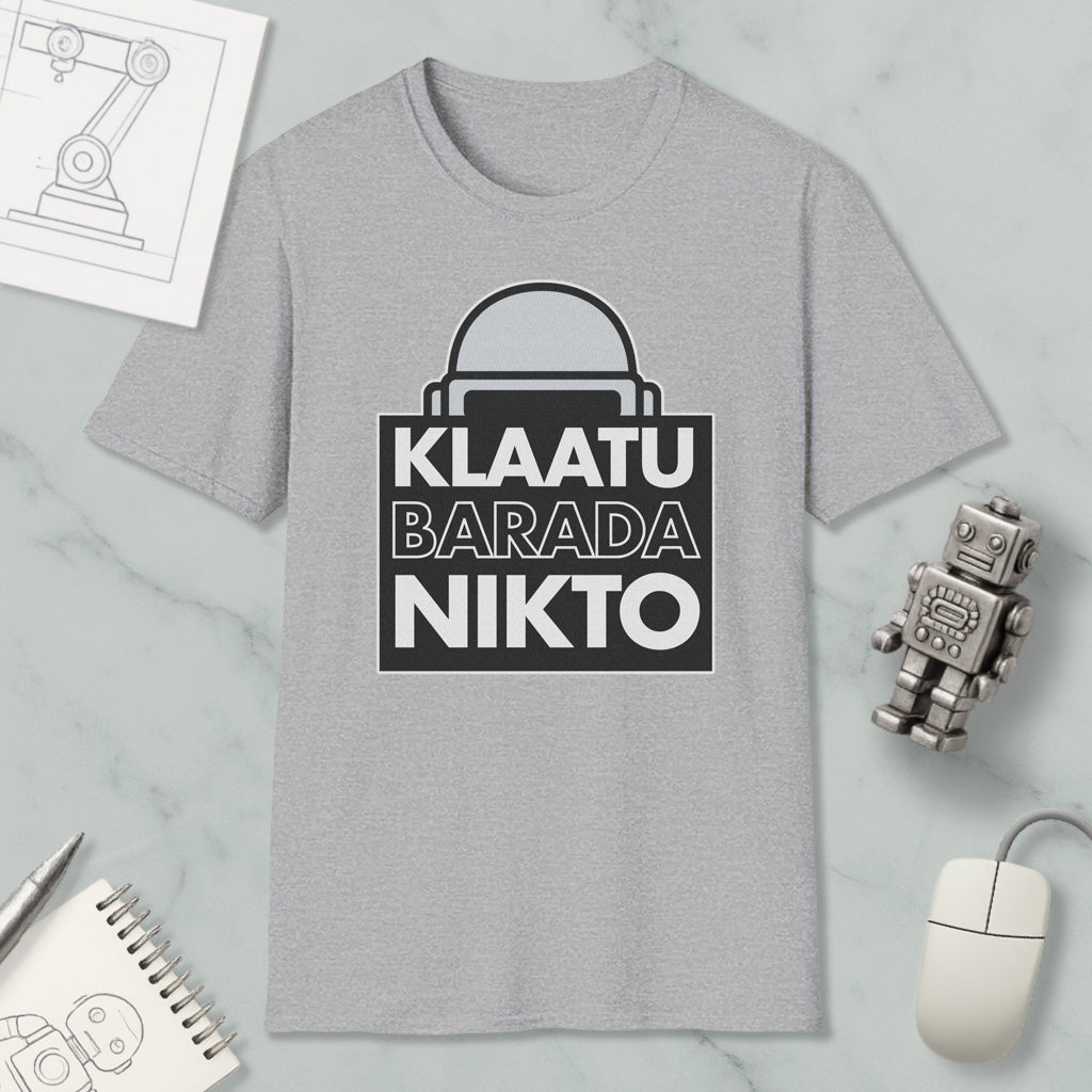 a gray t-shirt with a graphic design, a small robot, a computer mouse, and some other items arranged on a marble surface.