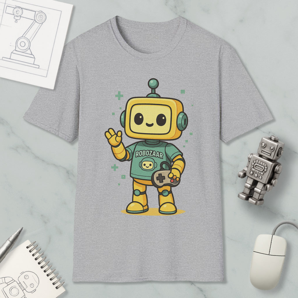 a gray t-shirt with a cartoon robot character wearing a green shirt and holding a game controller. The t-shirt is displayed on a marble surface, along with a computer mouse, a pen, and a notebook.