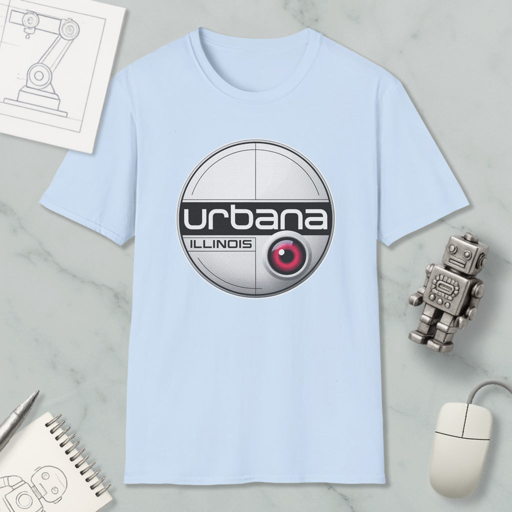 a light blue t-shirt with a circular logo, a computer mouse, a notebook, and a small robot on a marble surface.
