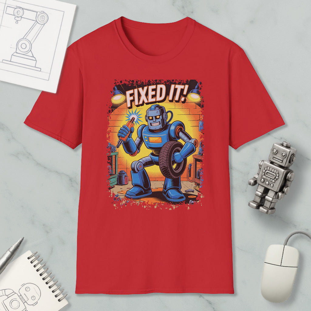 a red t-shirt with a cartoon robot holding a wrench and the text "FIXED IT!" printed on it. The t-shirt is surrounded by various objects, including a computer mouse, a notebook, and a robot figurine.
