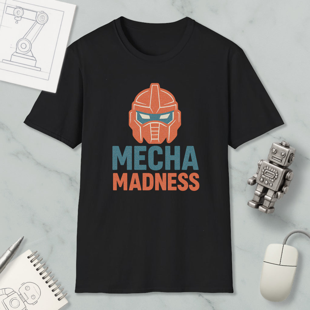 a black t-shirt with a graphic design of a robot head and the text "MECHA MADNESS" printed on it. The t-shirt is placed on a marble surface, along with a computer mouse, a notepad, and a small robot figurine.