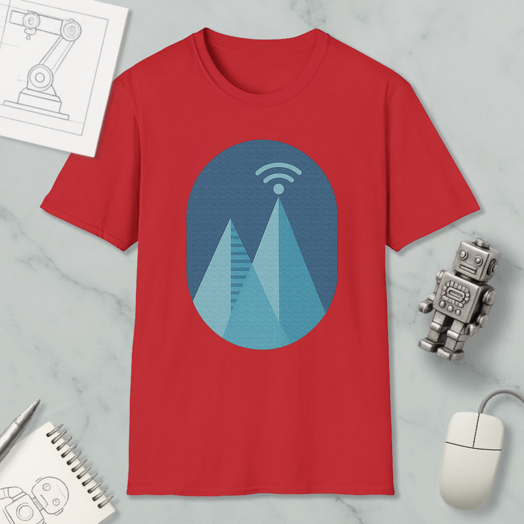 a red t-shirt with a graphic design of a mountain range, along with a computer mouse, a notebook, and a robot figurine.