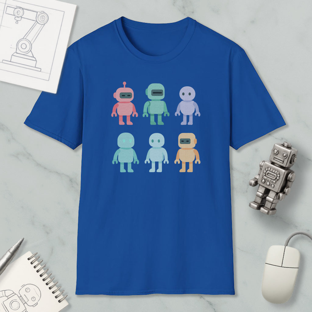 a blue t-shirt with a graphic design of six colorful robot characters, along with a computer mouse, a notebook, and a pen on a marble surface.
