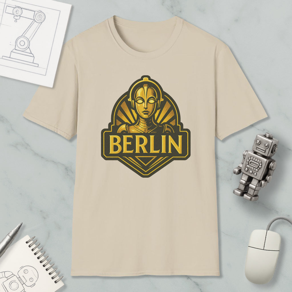 a beige t-shirt with a graphic design of a woman's face and the word "BERLIN" printed on it, along with various objects such as a computer mouse, a notebook, and a robot.