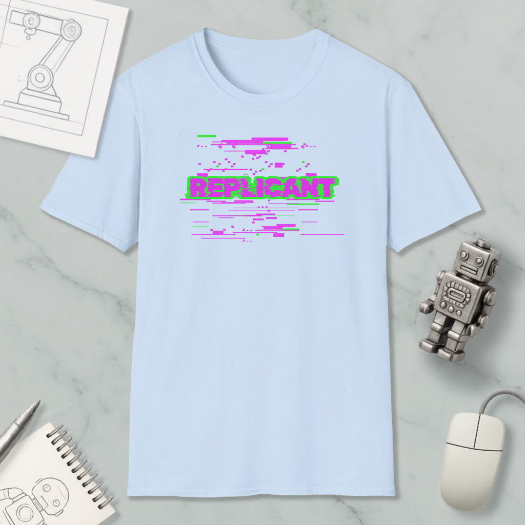 a light blue t-shirt with a graphic design, a computer mouse, a spiral notebook, and a small robot figurine.