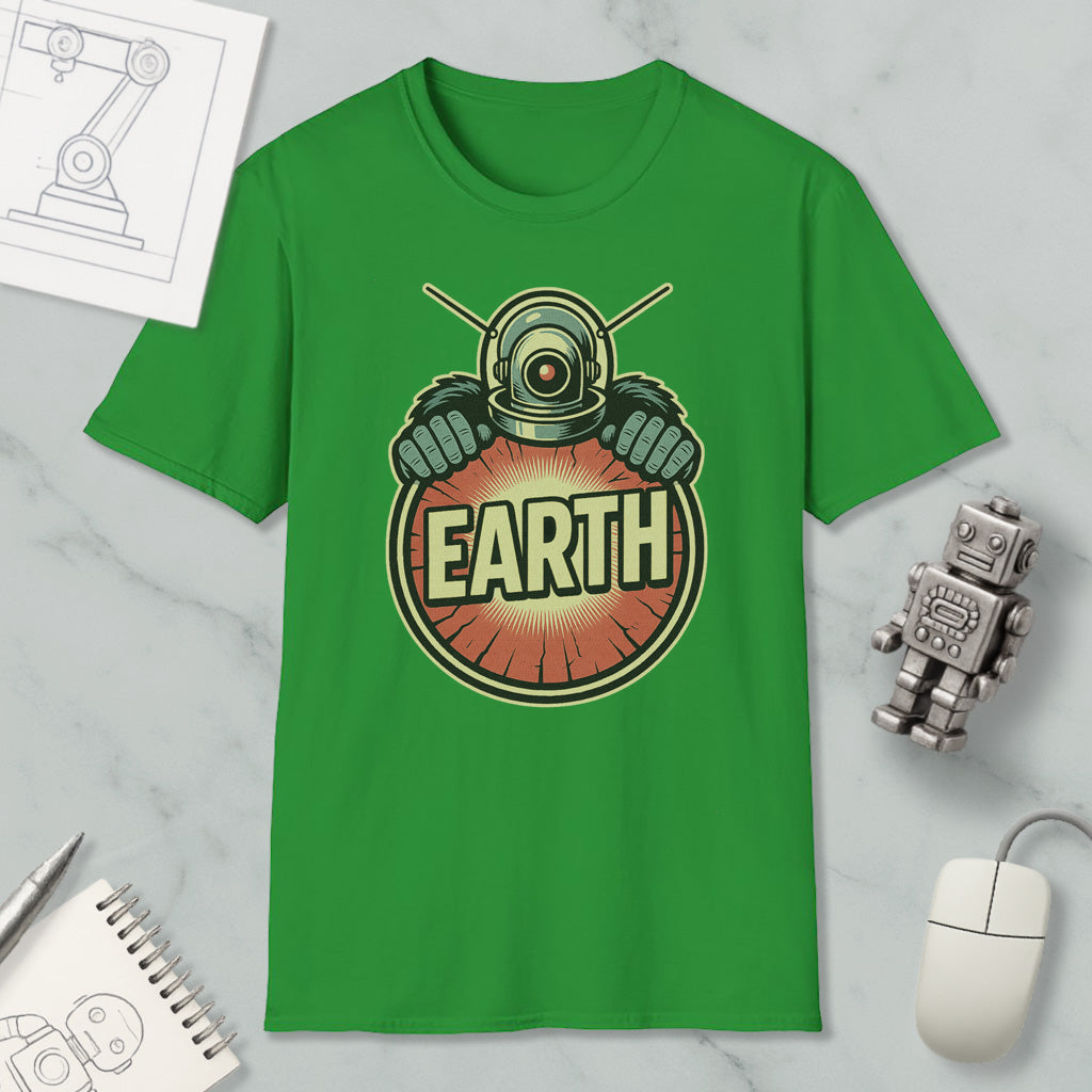 a green t-shirt with a graphic design of a robot or submarine wearing a helmet and the word "EARTH" written on it. The t-shirt is placed on a marble surface, along with a computer mouse, a notebook, and a small robot figurine.