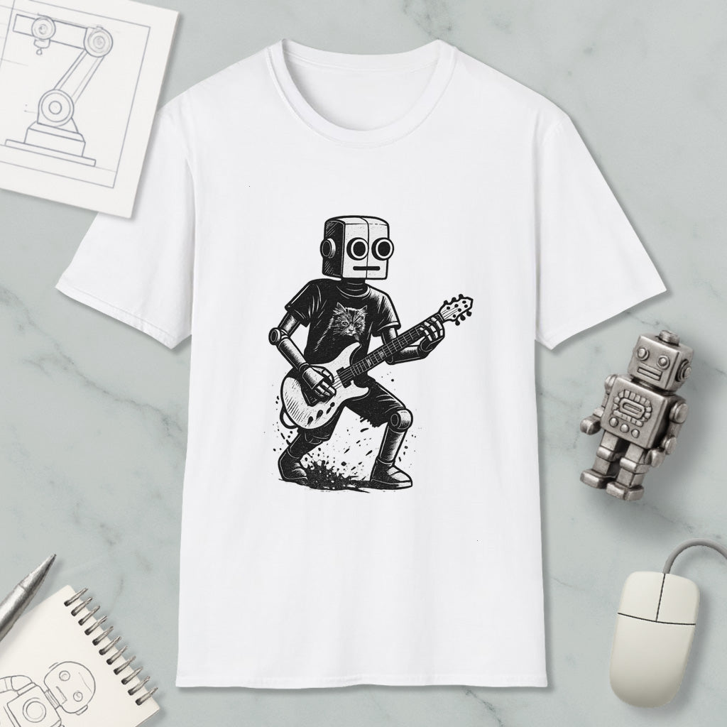 a white t-shirt with a black and white illustration of a robot playing a guitar. The t-shirt is placed on a marble surface, surrounded by various objects such as a computer mouse, a notebook, and a small robot figurine.