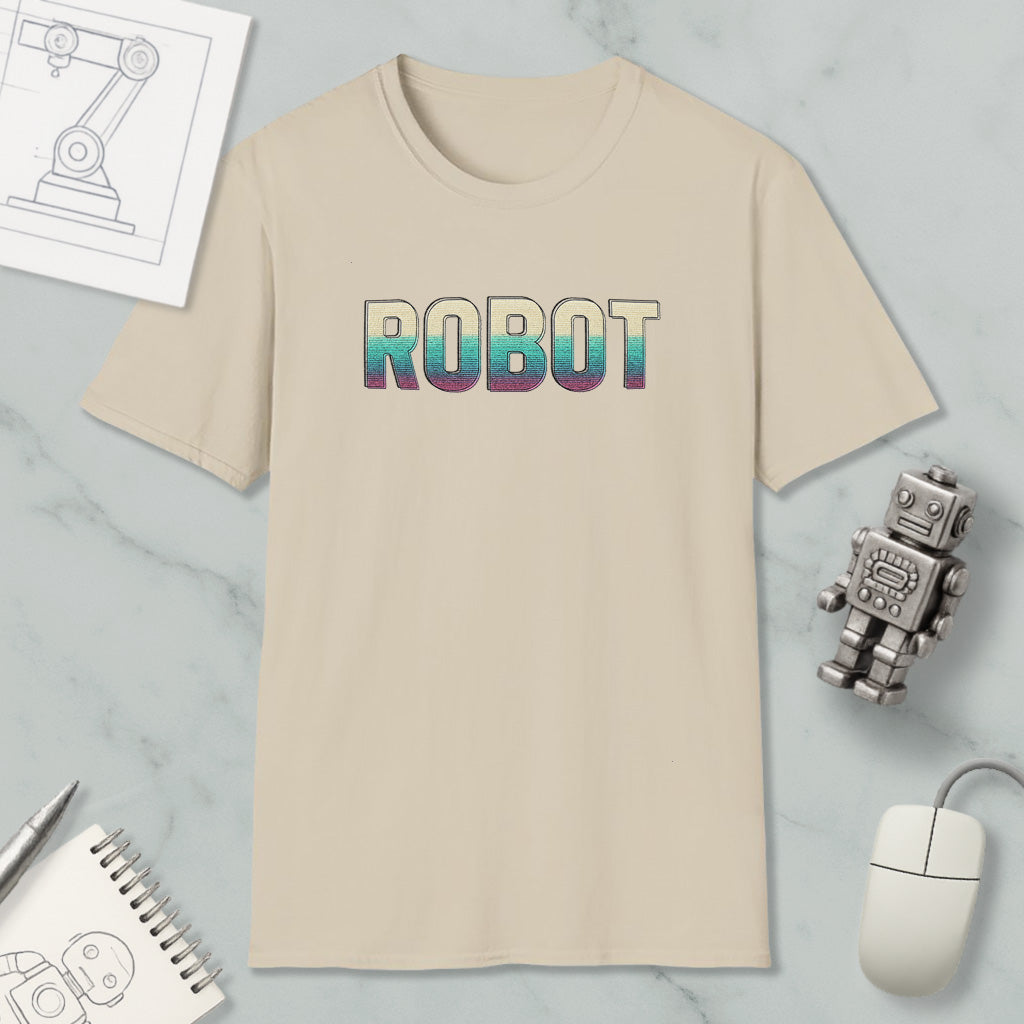 a beige t-shirt with the word "ROBOT" printed on it, along with a small robot toy and some other items such as a notebook and a mouse.