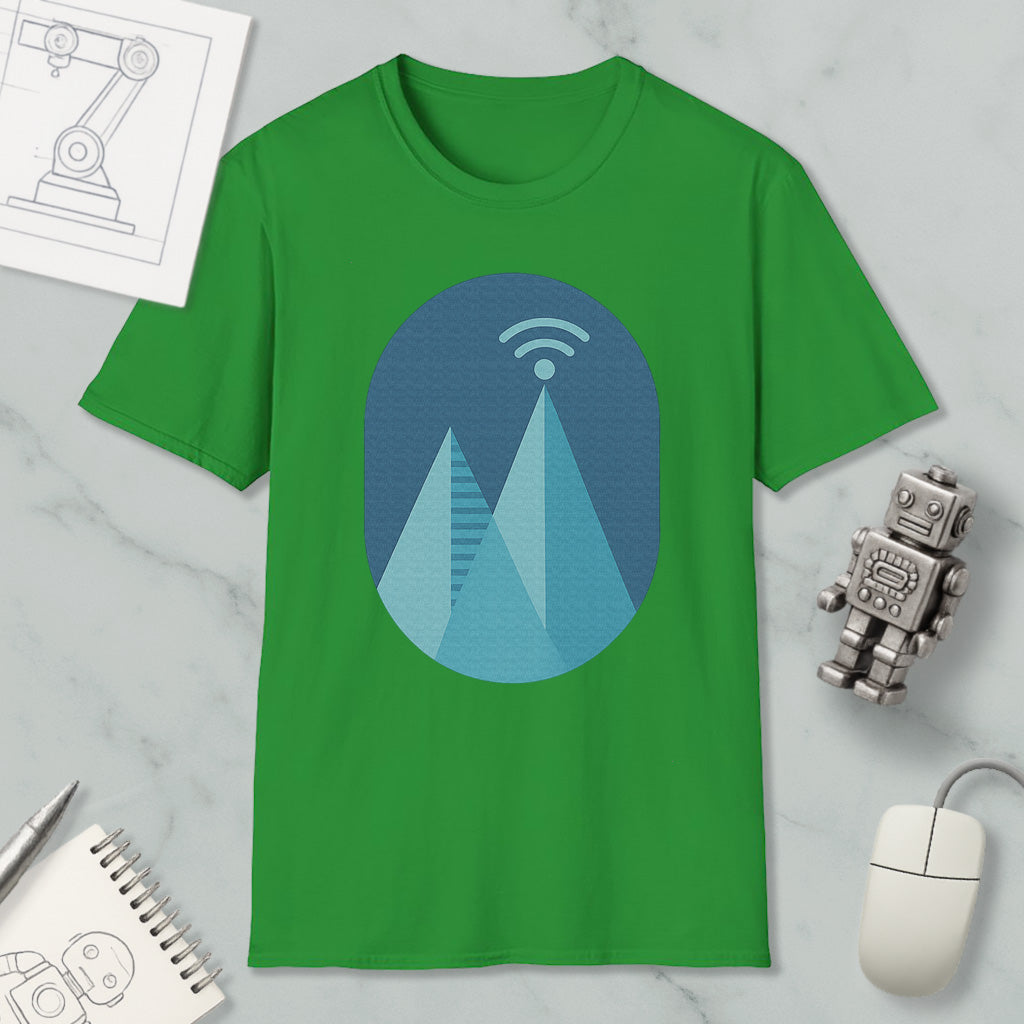 a green t-shirt with a graphic design of a mountain range, a Wi-Fi symbol, and a robot figure. The t-shirt is placed on a marble surface, along with a notebook, a mouse, and a pen.
