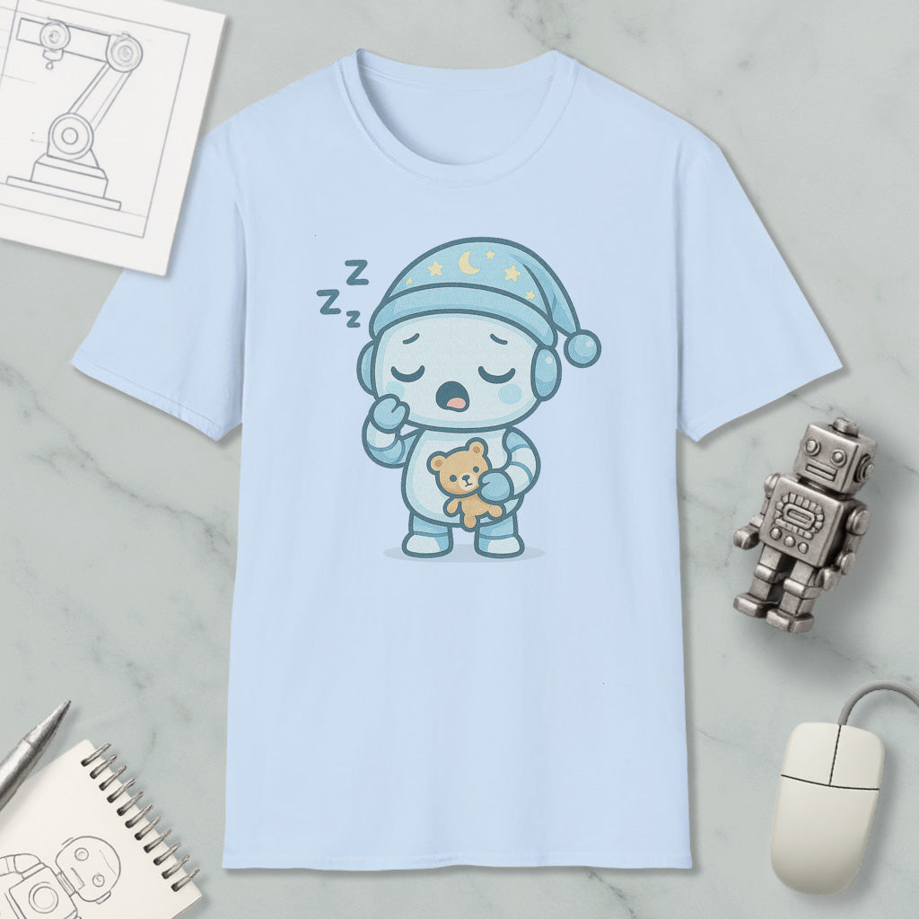 A light blue t-shirt with a cartoon robot wearing a blue hat and holding a teddy bear, along with a computer mouse and a robot toy, all placed on a marble surface.
