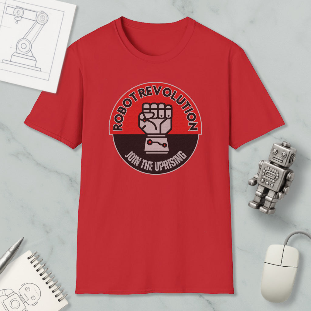 a red t-shirt with a graphic design, a computer mouse, a notebook, and a small robot figurine.